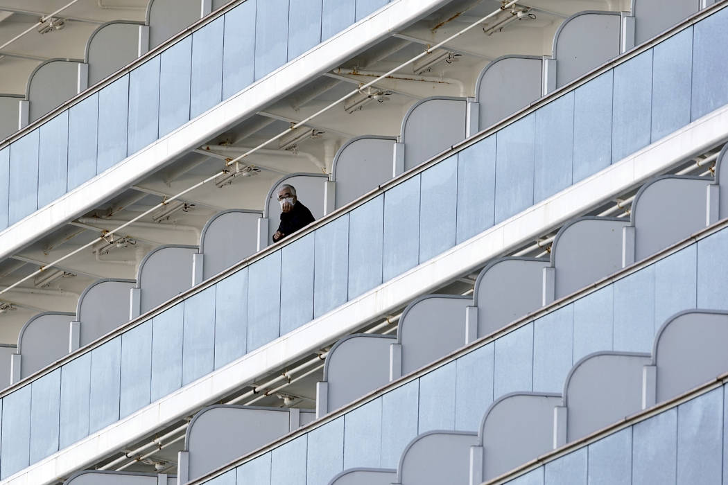 A passenger stand outside on the balcony of the cruise ship Diamond Princess anchored at the Yo ...