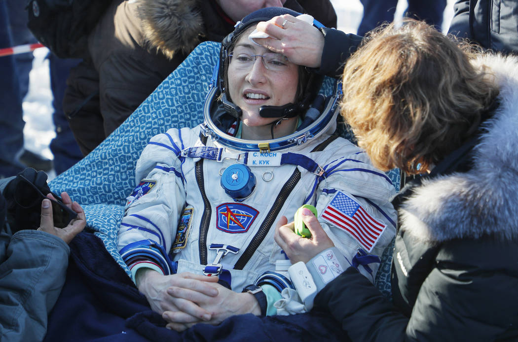Specialists help U.S. astronaut Christina Koch shortly after the landing of the Russian Soyuz M ...