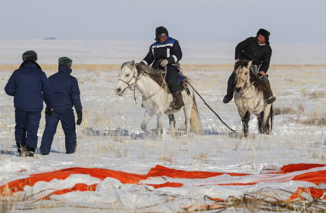 Kazakh shepherds ride near a parachute close to the place where Russian Soyuz MS-13 space capsu ...