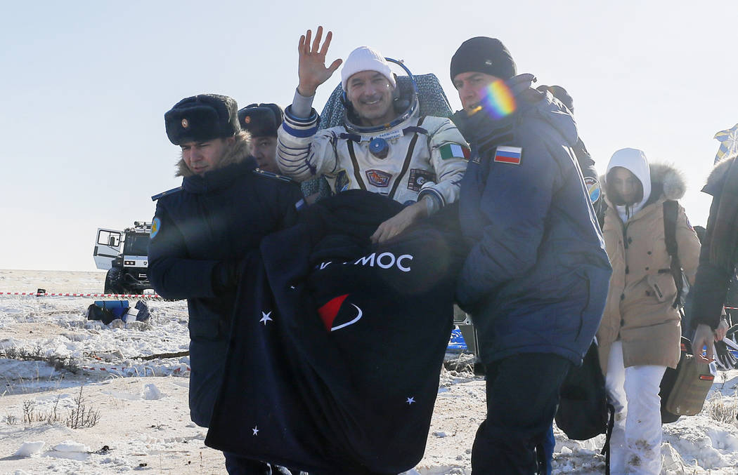 Rescue team members carry Italian astronaut Luca Parmitano shortly after the landing of the Rus ...