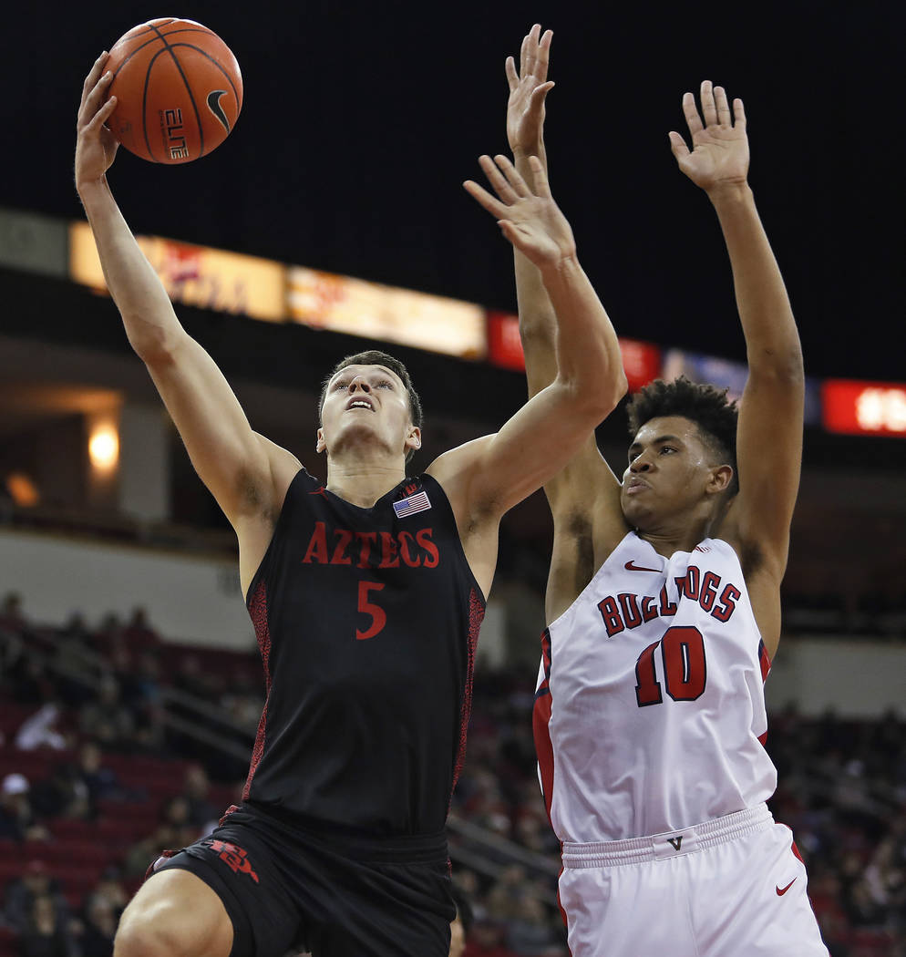 San Diego State's Yanni Wetzell shoots next to Fresno State's Orlando Robinson during the first ...