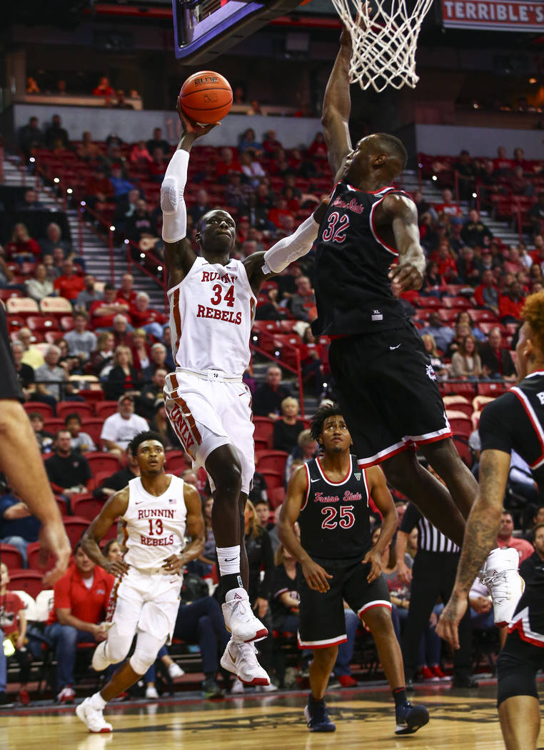UNLV's Cheikh Mbacke Diong (34) goes to the basket against Fresno State's Nate Grimes (32) duri ...