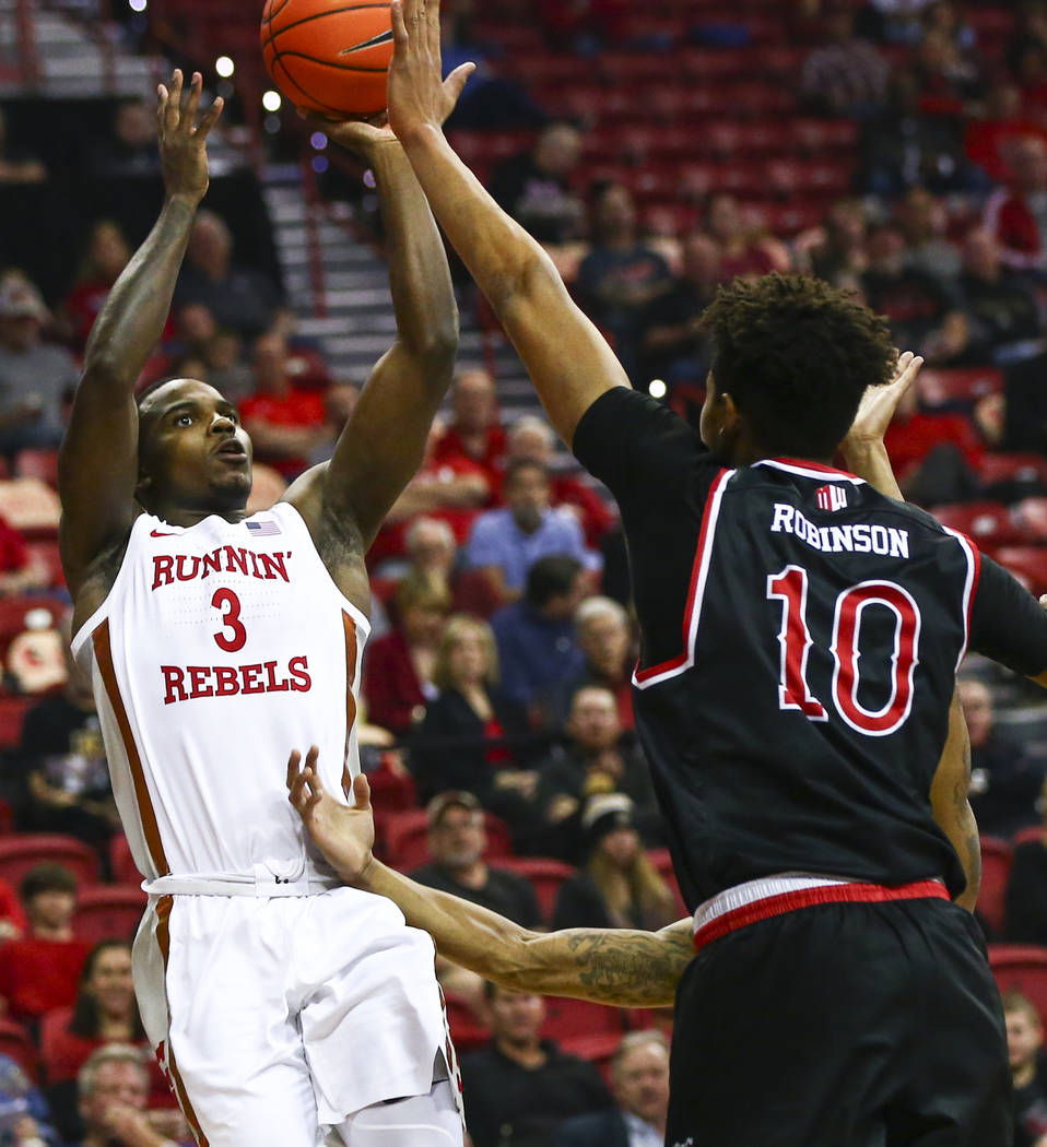 UNLV's Amauri Hardy (3) shoots over Fresno State's Orlando Robinson (10) during the first half ...