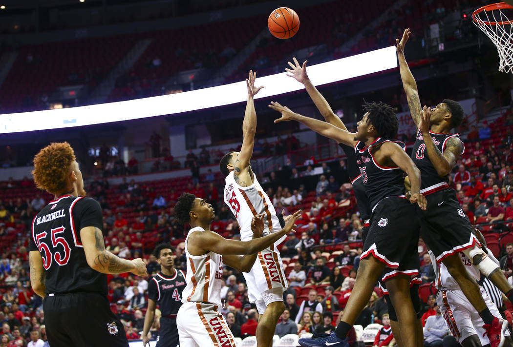 UNLV's Elijah Mitrou-Long (55) sends the ball over Fresno State's Anthony Holland (25) and New ...