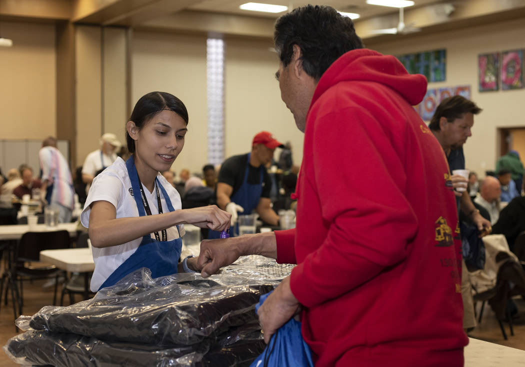 Volunteer Vicky Castellanos hands out CITYPAK backpacks at the Las Vegas Rescue Mission on Satu ...