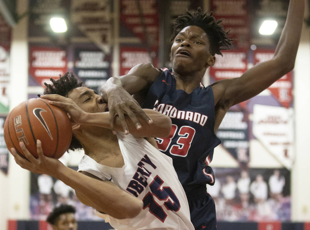 Liberty junior forward Greyson Montgomery (15) gets fouled on the way to the rim by Coronado so ...
