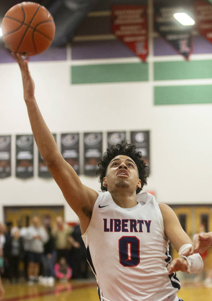 Liberty senior guard Julian Strawther (0) slices to the rim during the Patriots home game with ...