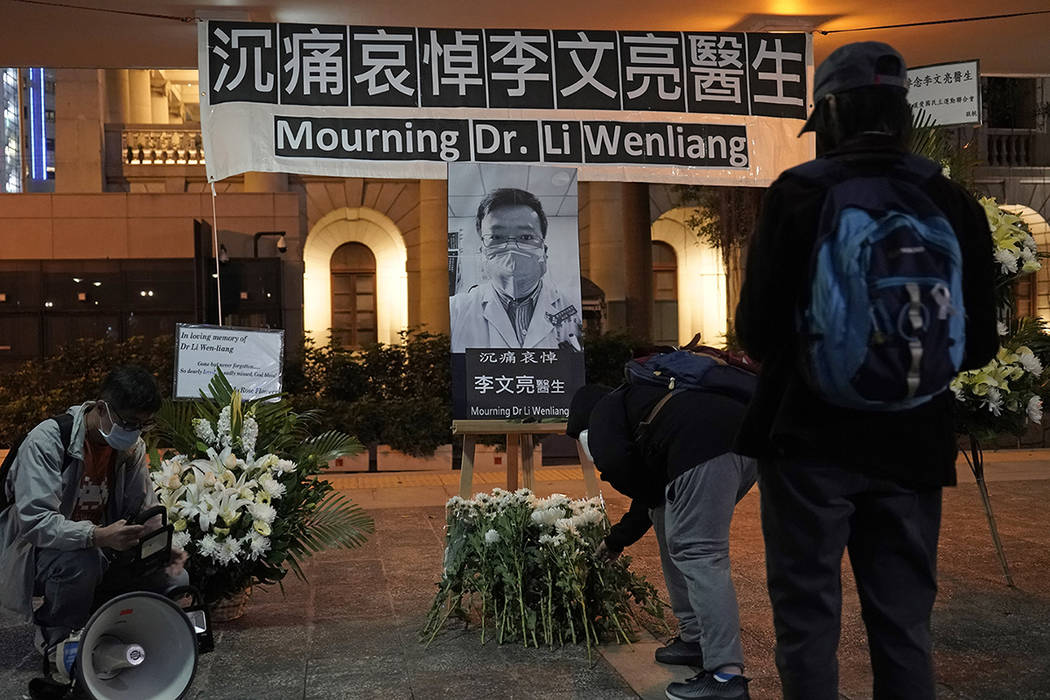 People attend a vigil for Chinese doctor Li Wenliang, in Hong Kong, Friday, Feb. 7, 2020. The d ...