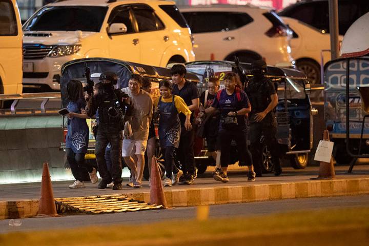 People who were able to get out of Terminal 21 Korat mall are escorted outside by armed command ...