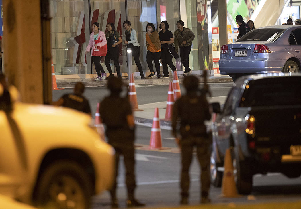 People who were able to get out of Terminal 21 Korat mall walk outside the building in Nakhon R ...