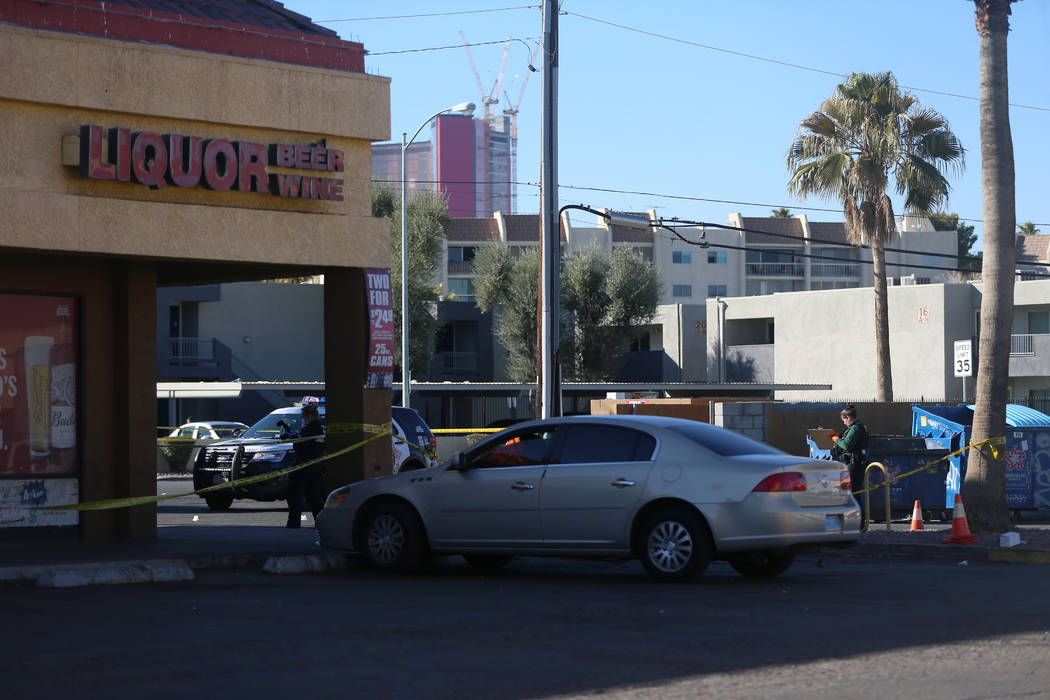 Police investigate a homicide in a shopping center at the intersection near Swenson Street and ...