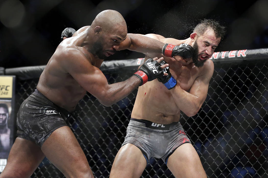 Jon Jones, right, goes for a take down of Dominick Reyes, left, during a light heavyweight mixe ...