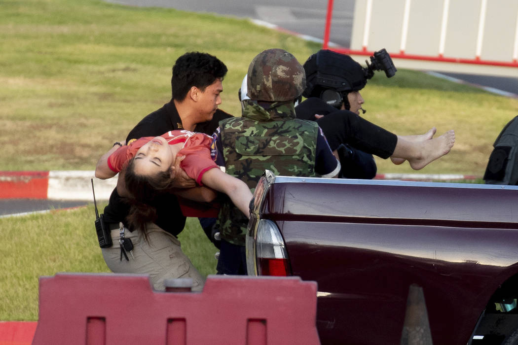Armed commando soldiers carry a person out of Terminal 21 Korat mall in Nakhon Ratchasima, Thai ...