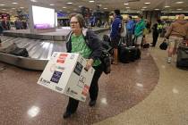 Ann Lovell carries her box of prescriptions after returning to Salt Lake City International Air ...