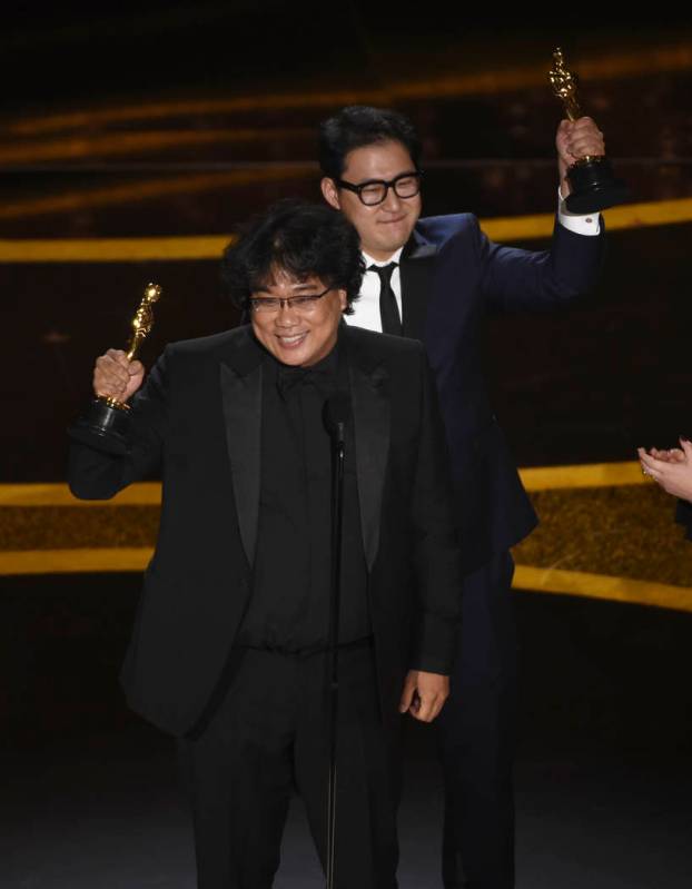 Bong Joon Ho, left, and Han Jin Won accept the award for best original screenplay for "Par ...