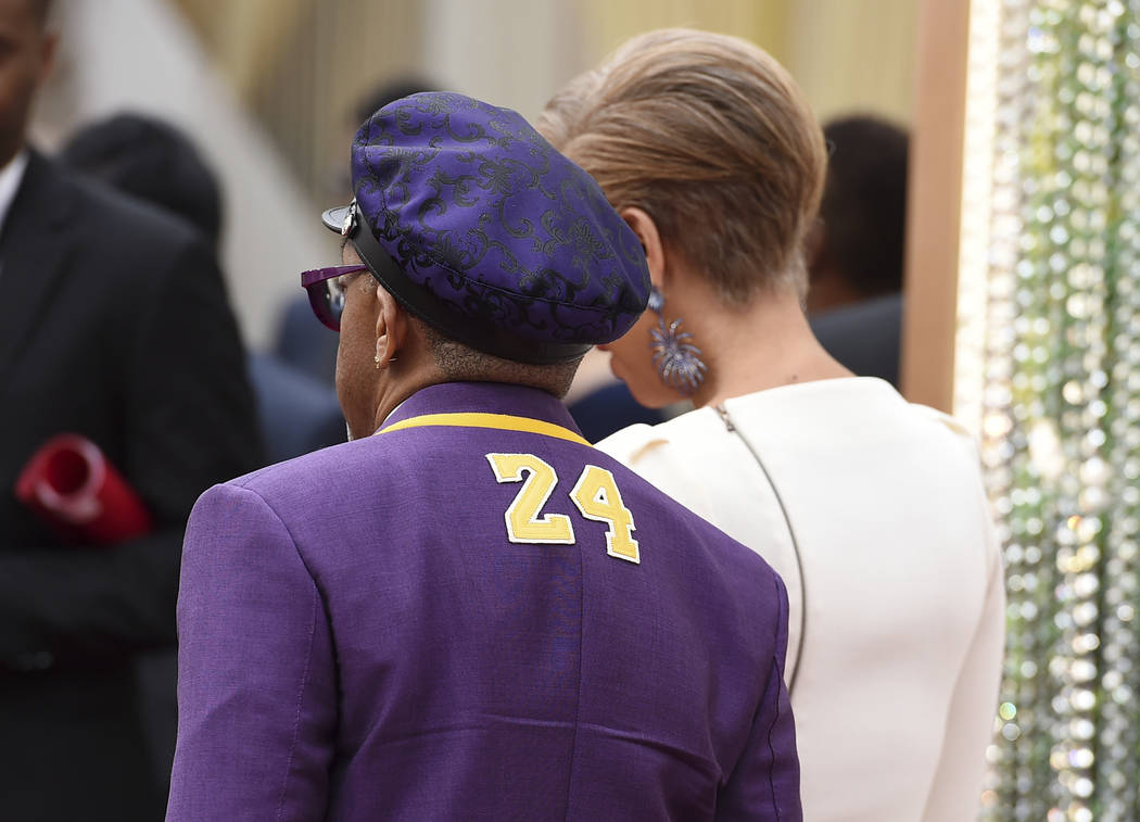 Spike Lee, left, wearing a jacket with the number 24 in honor of the late Kobe Bryant, and Tony ...
