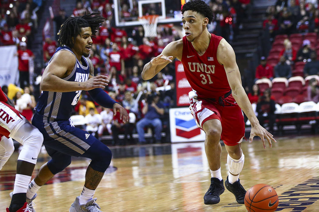 UNLV's Marvin Coleman (31) drives to the basket against UNR's Jazz Johnson (22) during the firs ...