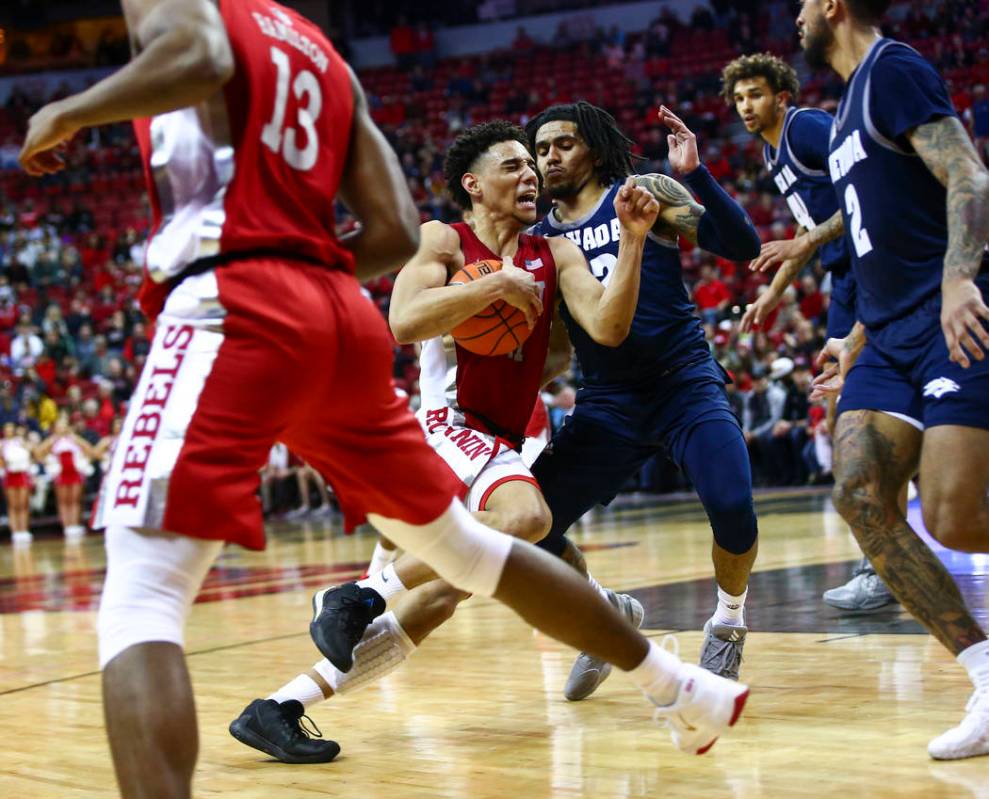 UNLV's Marvin Coleman (31) drives to the basket against UNR's Jazz Johnson (22) during overtime ...