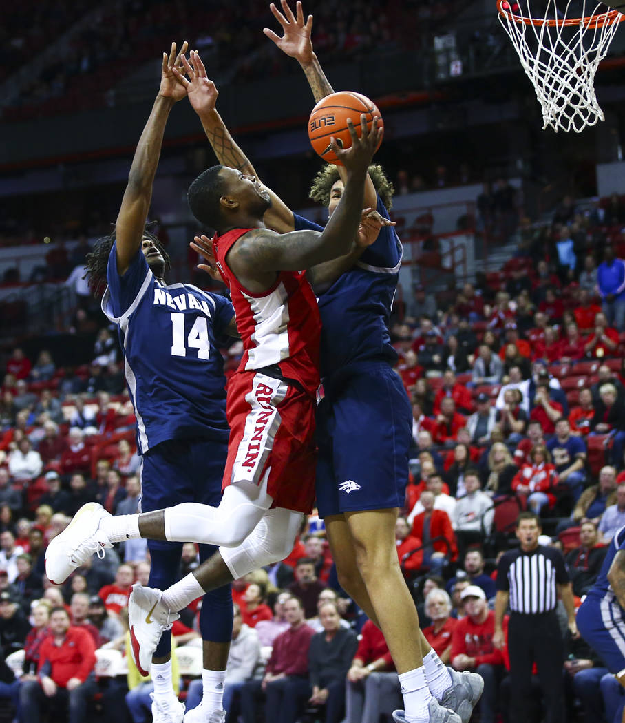 UNLV's Amauri Hardy (3) gets stopped at the basket between UNR's Lindsey Drew (14) and UNR's K. ...