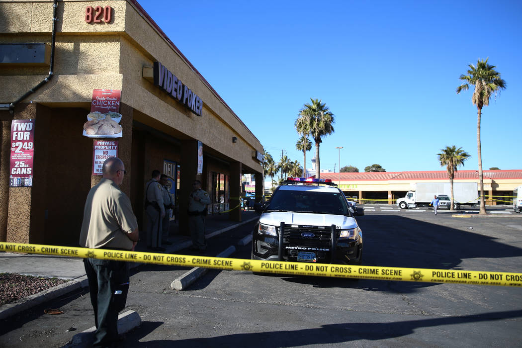 Police investigate a homicide in a shopping center at the intersection near Swenson Street and ...