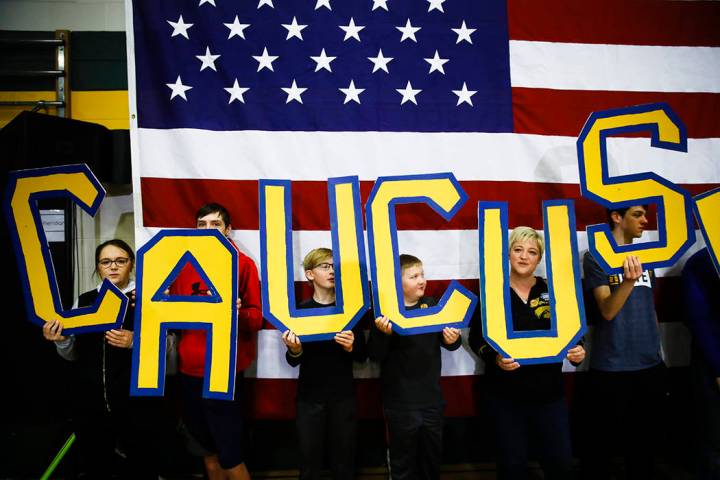 In this Sunday, Feb. 2, 2020, file photo, attendees hold letters that read "CAUCUS" during a ca ...