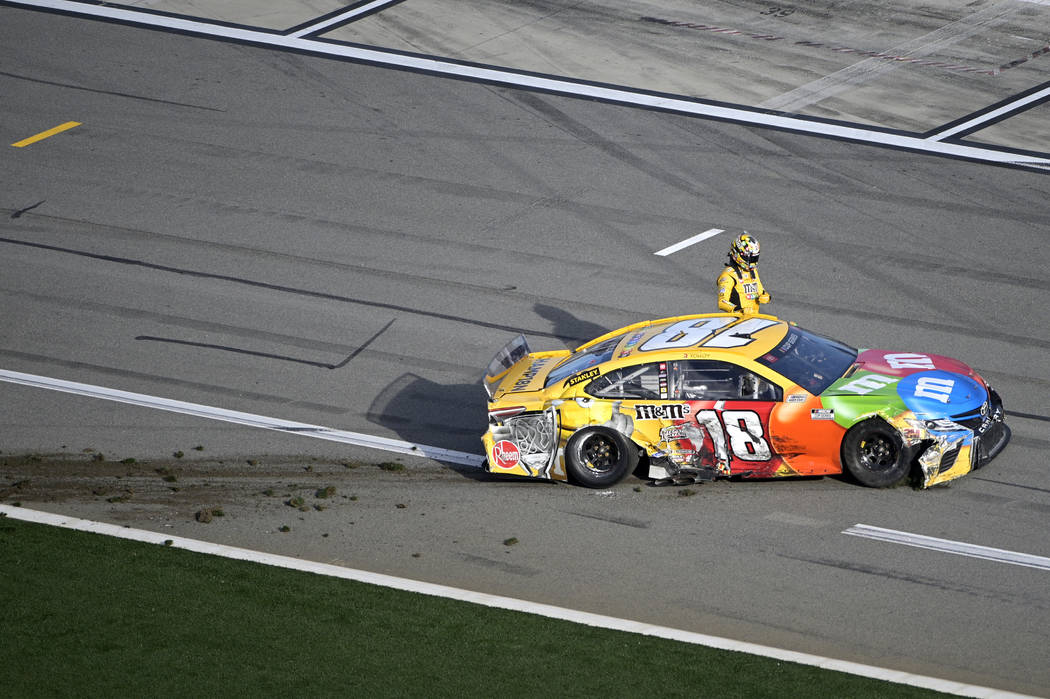 Kyle Busch (18) climbs out of his car after coming to a stop on pit road after colliding in Tur ...