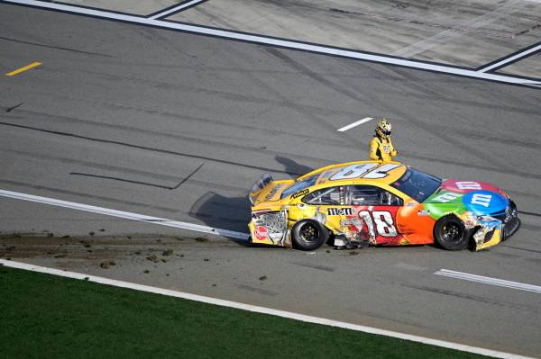 Kyle Busch (18) climbs out of his car after coming to a stop on pit road after colliding in Tur ...