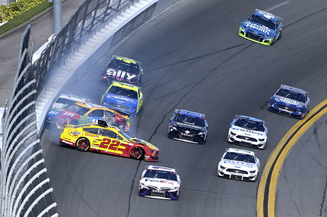 Joey Logano (22), Kyle Busch (18) and Brad Keselowski (2) collide in Turn 4 during the NASCAR D ...