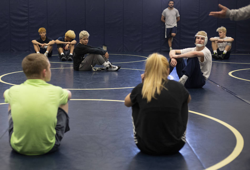 The wrestling team from Shadow Ridge High School listens to coaching staff at the end of practi ...