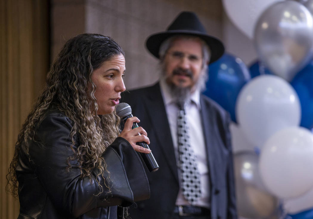 Taly Furer speaks about her deceased father Mordechai Bitton beside Rabbi Shea Harlig as they r ...