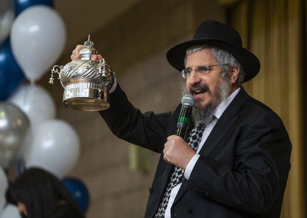 Rabbi Shea Harlig shows off the crown for their newest Torah as they ready to inscribe the fina ...