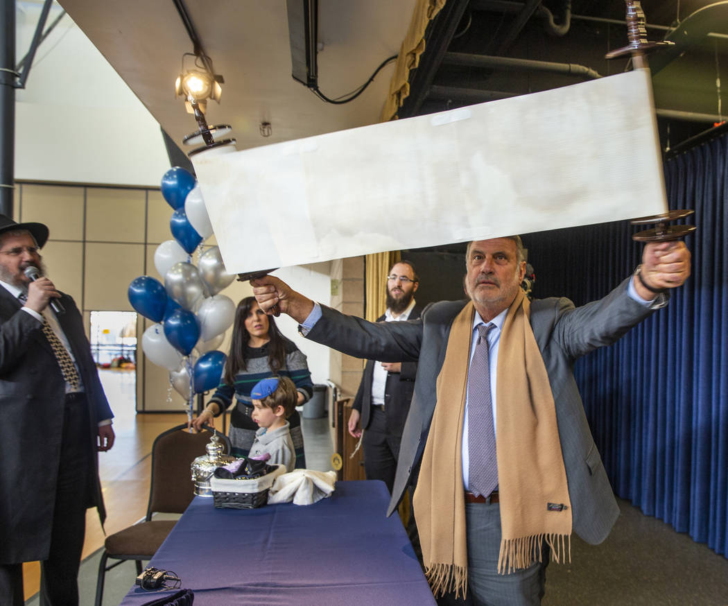 Sonny Kahn, right, shows off a newly inscribed Torah to all in attendance at a ceremony for it ...