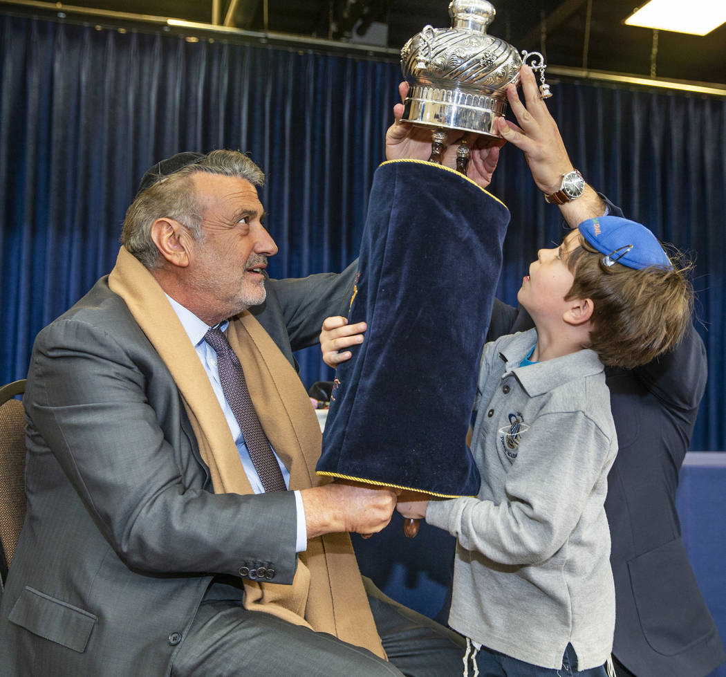Sonny Kahn, left, holds a newly inscribed Torah with the help of student Eitan Yafee, 6, at the ...