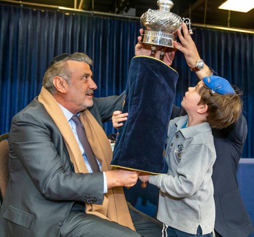 Sonny Kahn, left, holds a newly inscribed Torah with the help of student Eitan Yafee, 6, at the ...