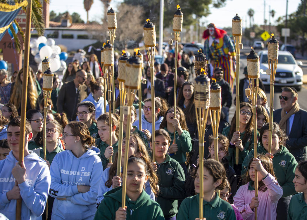 Chabad of Southern Nevada members march with torches while carrying their new Torah about the n ...