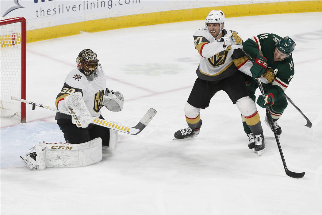 Vegas Golden Knights' Shea Theodore, second from right, keeps Minnesota Wild's Zach Parise in c ...
