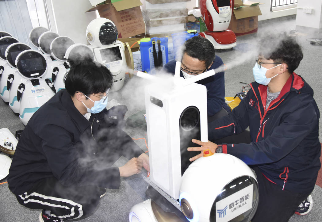 In this photo released by Xinhua News Agency technicians work on a second generation disinfecti ...
