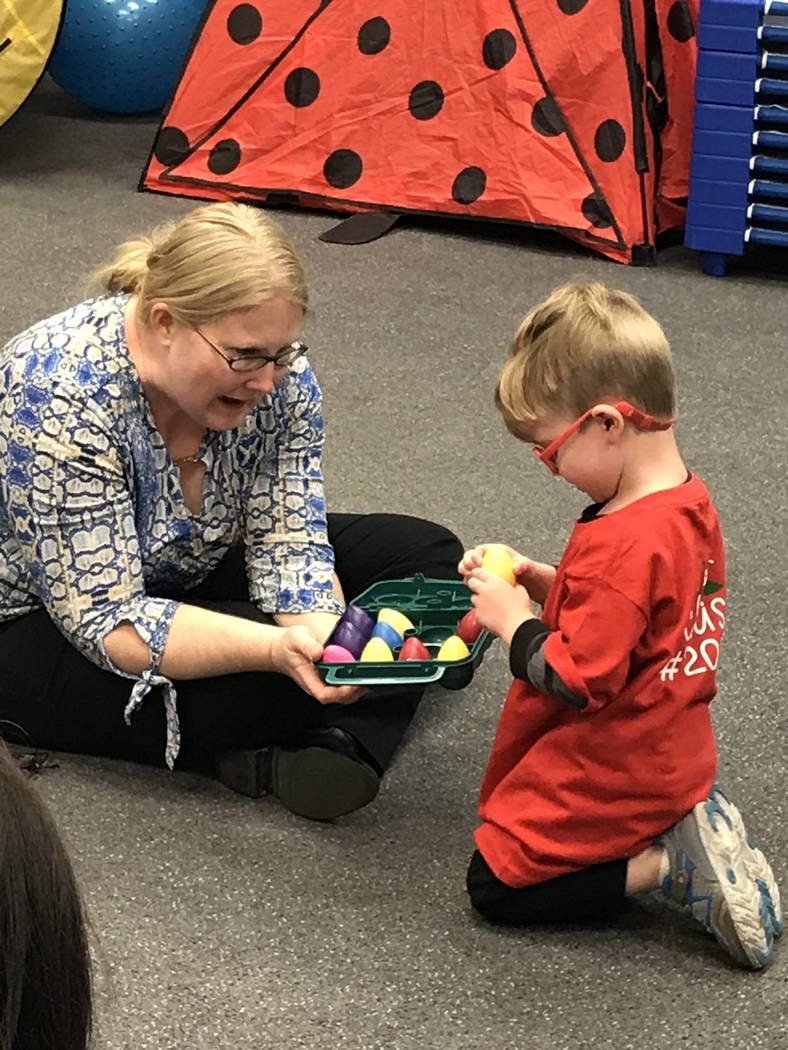 Emily Rawlings with Dynamic Music Therapy lets preschooler Levi pick a shaker during a music th ...