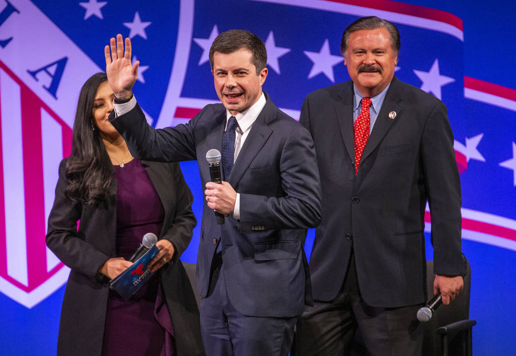 Former South Bend, Ind., Mayor Pete Buttigieg arrives on stage with Leticia Castro and Domingo ...