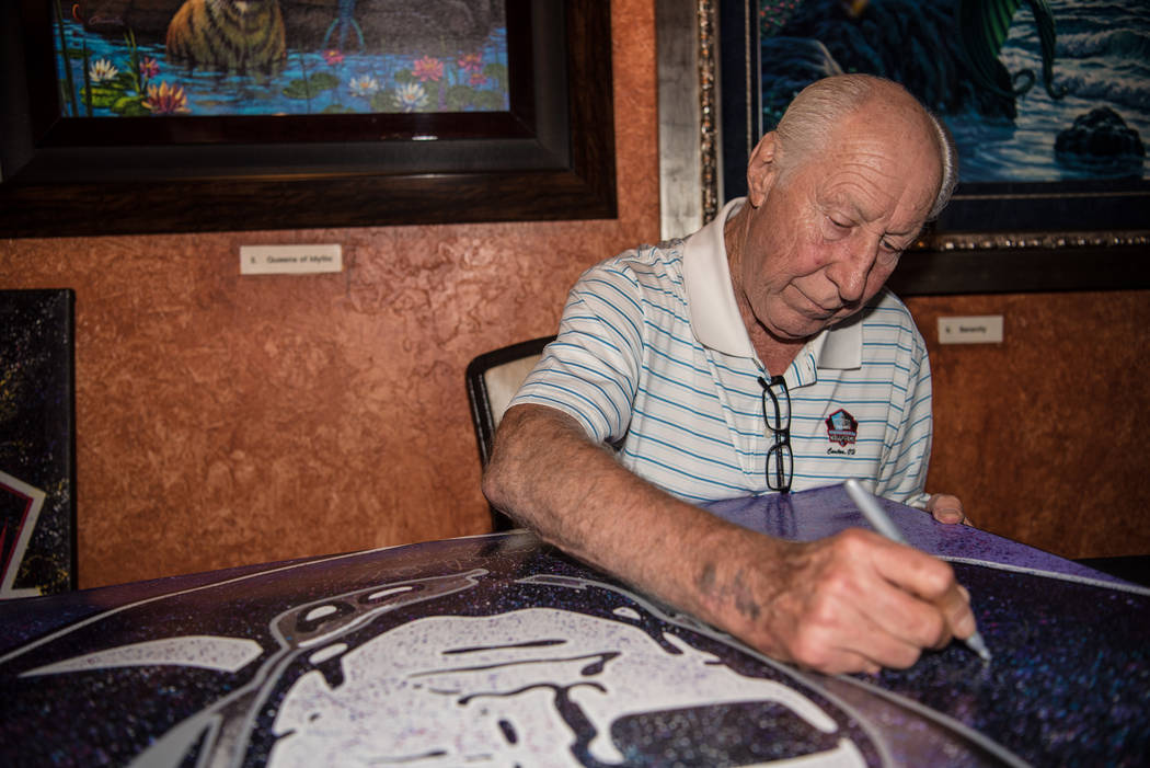 Former Raiders' wide receiver Fred Biletnikoff signs a large canvas at the Mermaid Lounge at Si ...