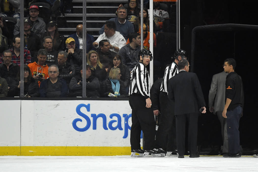 Officials leave the ice after the game between the Anaheim Ducks and the St. Louis Blues was po ...