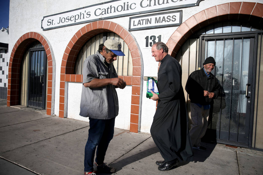 The Rev. Courtney Krier visits with people before a free breakfast at St. Joseph's Catholic Chu ...