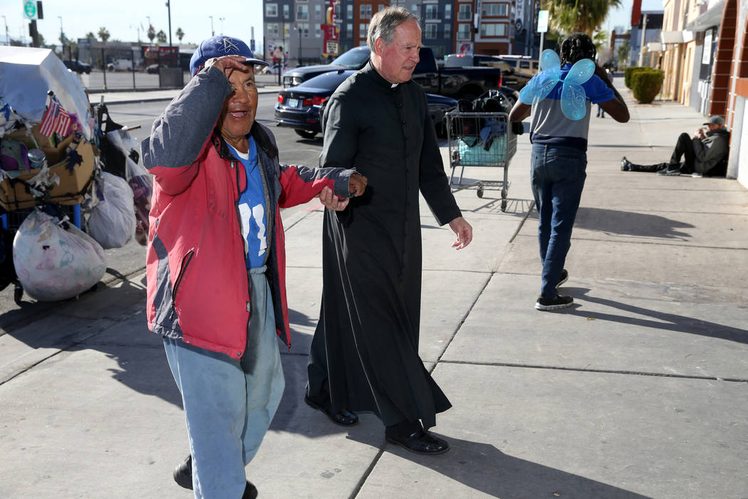 The Rev. Courtney Krier helps Tony Romez to a free breakfast at St. Joseph's Catholic Church on ...