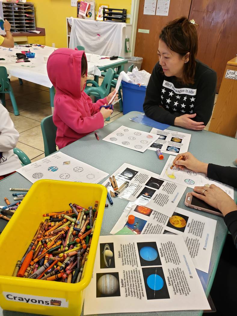 Fumika Takayama, working with her youngest child on labeling the solar system on Feb. 6, has ta ...