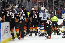 Members of the St. Louis Blues and Anaheim Ducks gather on the ice as Blues defenseman Jay Bouw ...