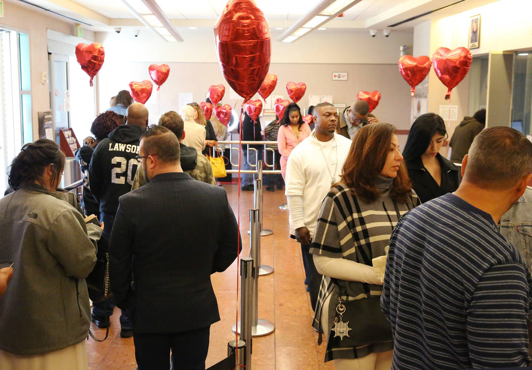 People wait in line at the Marriage License Bureau to get their marriage license on Friday, Feb ...