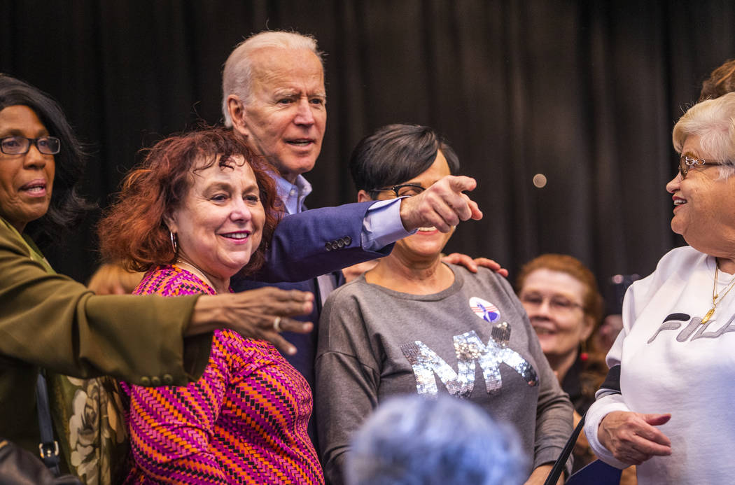 Former Vice President Joe Biden joins a group photo with attendees following an early vote eve ...