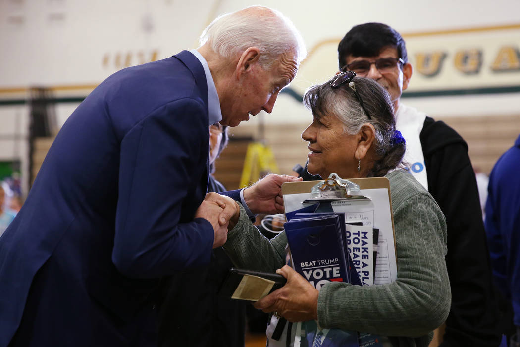 Democratic Presidential Candidate Joe Biden, left, speaks to campaign volunteer Rosie Martinez ...