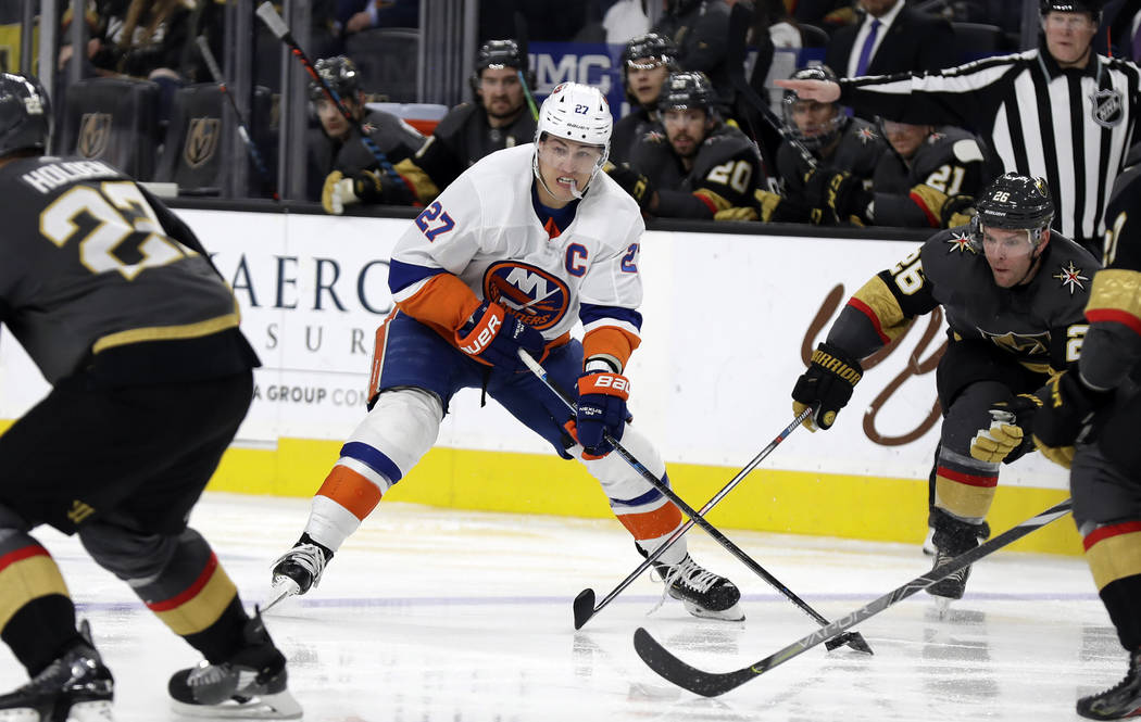 New York Islanders forward Anders Lee (27) looks to pass the puck as Vegas Golden Knights cente ...