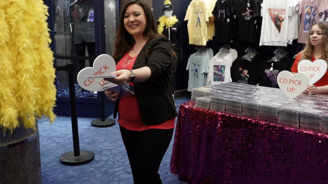 Westgate Las Vegas staffer Jamie Papp hands out one of 900 Barry Manilow "Night Songs II" CDs t ...